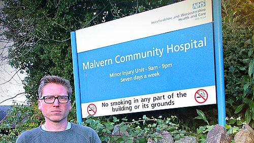 Cllr Dan Boatright-Greene next the Malvern Hills NHS sign